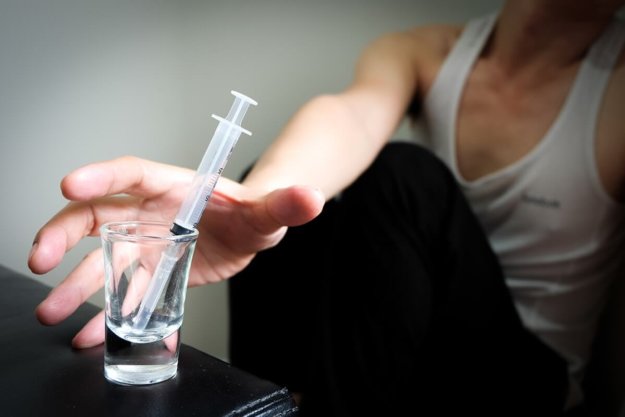 teen substance abuse treatment Man reaching for needle in need of teen substance abuse treatment